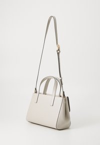 Sac à main en cuir gris clair avec deux poignées supérieures et une bandoulière amovible. Présente des lignes épurées et une forme structurée.