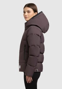 Chaqueta de plumas morada con capucha, que presenta un bolsillo con cremallera en el lado izquierdo del pecho y acentos en negro. Tejido suave e insulated con una forma estructurada.