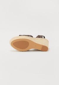 Brown leather wedge sandal with woven jute platform, featuring an ankle strap and a smooth, rounded sole.