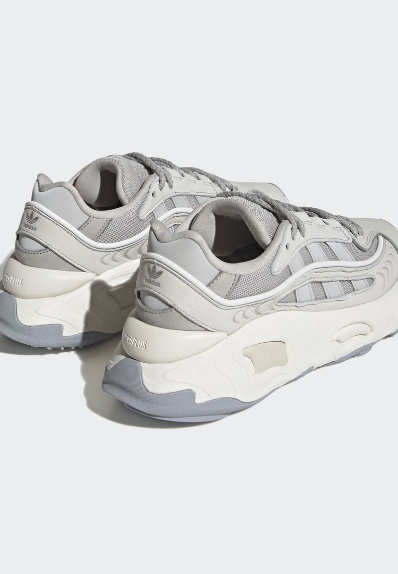 Graue Sneakers mit einem Obermaterial aus Mesh und Synthese sowie strukturierten Akzenten. Dicke weiße Sohle mit grauen Akzenten. Schnürverschluss für einen sicheren Sitz.