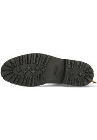 Suela de bota de goma con surcos profundos para tracción, que presenta una superficie texturizada y un talón reforzado para mayor durabilidad. Color negro con patrones estriados.