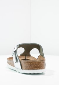 Sandale en cuir argenté avec une semelle en liège, semelle en caoutchouc blanche et détails de sangle réglable. Design ouvert au dos avec une surface texturée.