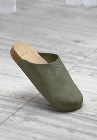 Πράσινο ελιάς παπούτσι χωρίς κορδόνια από σουέτ με στρογγυλεμένη μύτη, ταμπά δερμάτινο πάτο και διακριτικό ανάγλυφο λογότυπο στο μπροστινό μέρος.