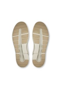 Białe sneakersy z beżowymi gumowymi podeszwami z wzorzystym bieżnikiem, teksturowanymi detalami i segmentowanym designem dla lepszej przyczepności i elastyczności.