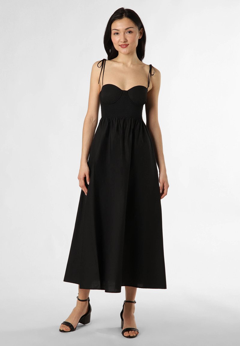 Schwarzes Kleid mit tailliertem Oberteil, verstellbaren Trägern und einem fließenden Rock. Hergestellt aus atmungsaktivem Stoff, mit glatter Textur und knöchellangem Saum.
