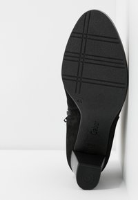 Semelle de chaussure à talon pour femme noire avec motif antidérapant, taille 4,5, et nom de marque « Gabor » visible en dessous.