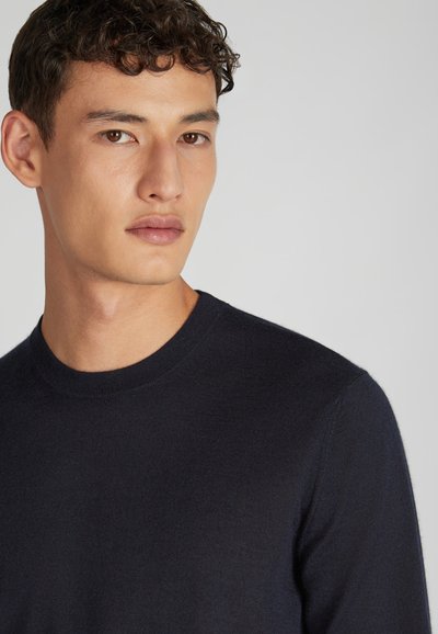 Dunkelblauer Rundhals-Pullover aus gestricktem Stoff, mit glatter Textur und langen Ärmeln. Einfaches Design ohne Muster oder Akzente.