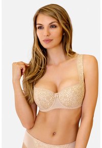 Beżowy stanik koronkowy z kwiatowym wzorem, z wsparciem w postaci fiszbin, z falbaniastymi brzegami, z regulowanymi ramiączkami i centralnym detalem w postaci kokardki.