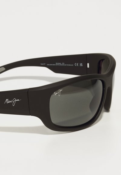 Mustad mustad Maui Jim prillidega hallid päikeseprillid, kõrgekvaliteedilisest plastist raam, millel on valge logoga detailid templitel. Omab ümbermõõtvat disaini.