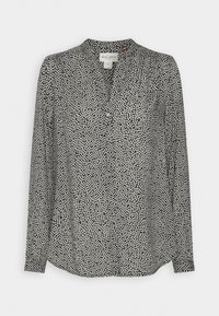 Blouse noire à manches longues avec un petit motif de points blancs irréguliers, encolure en V avec patte de boutonnage partielle et col rond sans col.