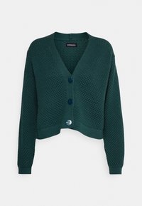 Tmavě zelený pletený zkrácený cardigan s texturovaným vzorem, výstřihem do V a třemi velkými tmavými knoflíky vpředu.