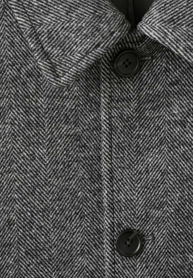 Grå herringbone-kappa i en texturerad ullblandning, med en spetsig krage och tre svarta knappar fram.