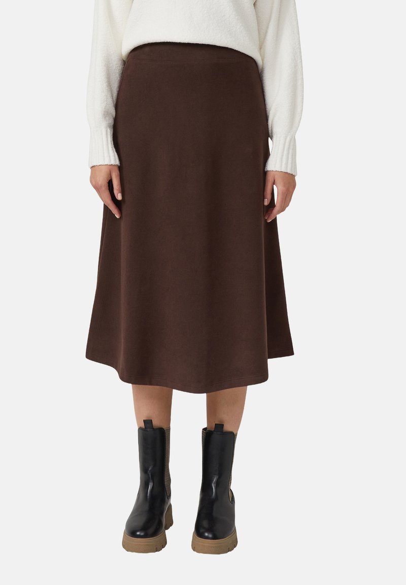 Bruine midilengte rok van zachte stof met een wijde, uitlopende pasvorm. Gecombineerd met zwarte enkellaarsjes met een gestructureerd ontwerp.