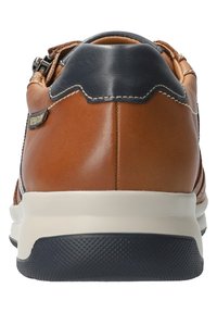 Basket en cuir marron avec des accents bleus marine, une semelle texturée et un zip sur le côté. Présente des coutures le long des seams et un placement de logo.