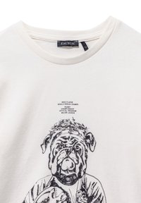T-shirt bianco in cotone con grafica nera di un bulldog in abbigliamento sportivo, con testo che dettaglia un campionato di rugby e collo rotondo.