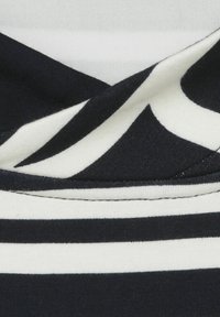 Marineblauer Stoff mit weißen Streifen in unterschiedlichen Breiten, mit glatter Textur und gefaltetem Design, das kontrastierende Farben zur Schau stellt.