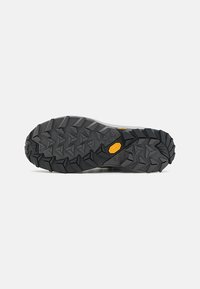 Schwarze Gummisohle mit aggressivem Muster für Traktion. Vibram-Logo prominent platziert. Glatte, leicht angehobene Mittelsection.