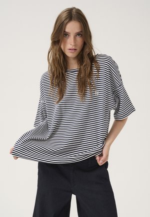 T-shirt en coton rayé bleu marine et blanc, coupe oversize avec un col rond et des manches courtes. Petit logo sur la poitrine.