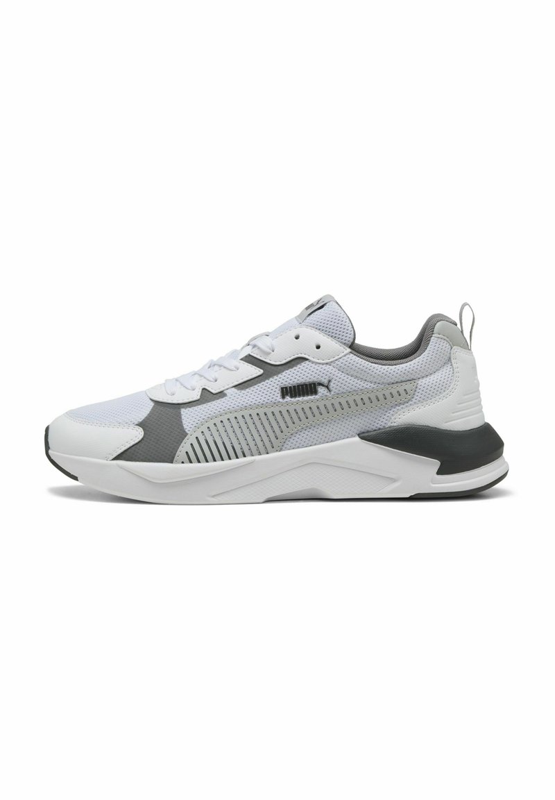 White athletic shoe with gray accents, mesh upper, textured sole, and flat laces. Features a rear pull tab and branding on the side.