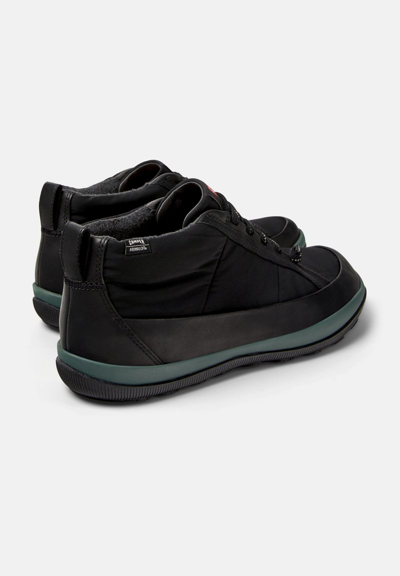 Pair of black mid-top sneakers with green midsoles, lace closure, and a small "Camper PrimaLoft" fabric tag on the side.