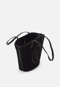 Svart bucket bag gjord av texturerad tyg med en mjuk finish, med läderdetaljer, långa remmar och en framträdande logotypdetalj.