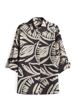 Chemise à manches courtes noire et crème avec un motif de feuilles audacieux. Fabriquée en tissu léger, elle est dotée d'un col classique et de boutons.