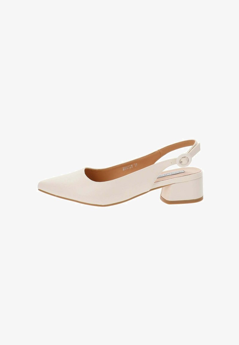 Zapato de piel blanca tipo slingback con punta afilada, tacón bajo y un acento circular en la correa. Textura suave y diseño minimalista.