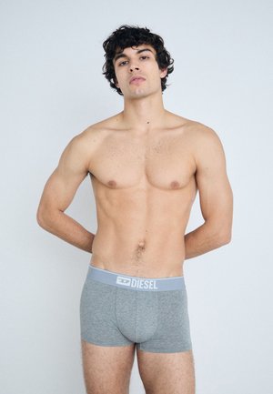 Boxer-briefs gris en tissu doux avec une ceinture bleue portant le logo "DIESEL". Le design est ajusté et basique, sans motifs.