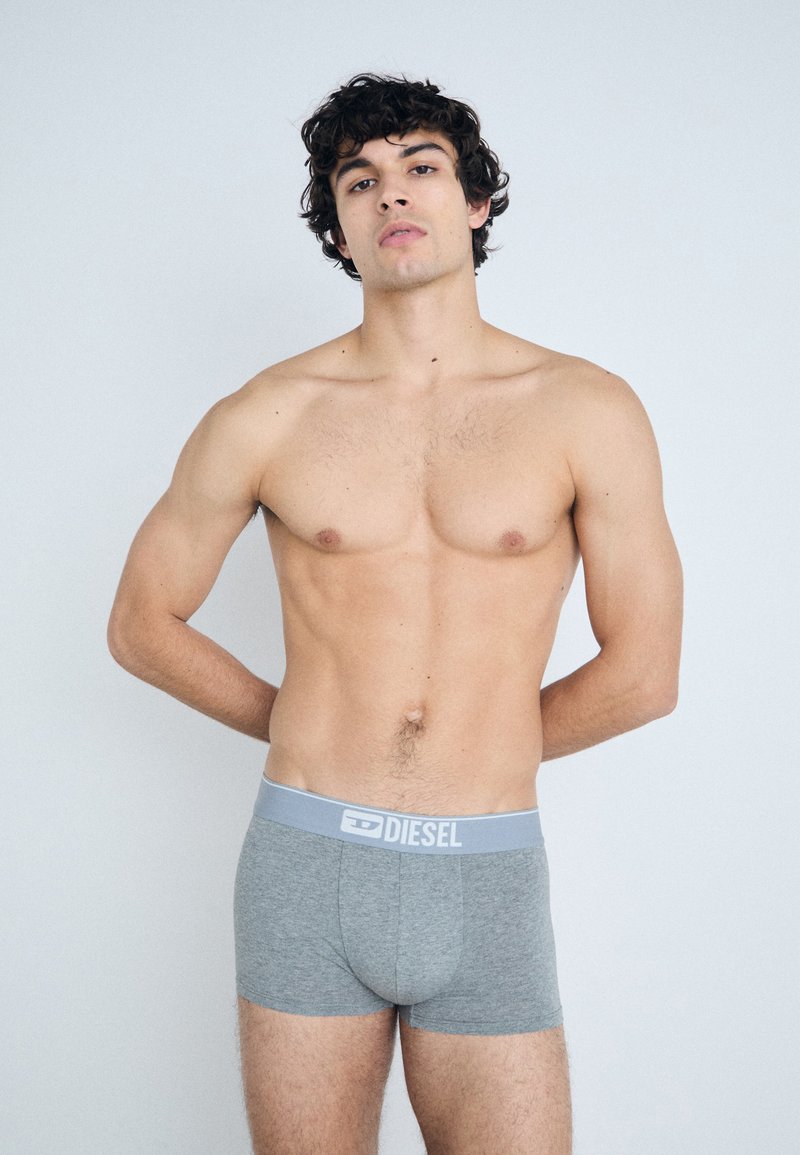 Gray boxer briefs made of soft fabric with a blue waistband featuring the "DIESEL" logo. The design is fitted and basic without patterns.