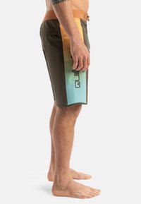 Herrsim shorts i brunt, med en gradientdesign som övergår från orange till blått, med en logotryck på sidan.