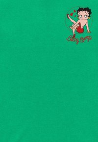 T-shirt verde con un personaggio dei cartoni animati stampato, con capelli neri, vestito rosso, grandi occhi e cuori, accompagnato dal testo "Betty Boop."