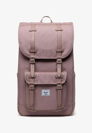 Sac à dos mauve avec des sangles de boucle à l'avant, fermeture à rabat, poche avant avec boucles et étiquette de marque Herschel sur la poche.