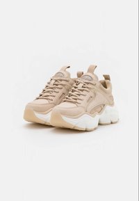 Baskets beige épaisses avec semelles blanches épaisses, tige en mesh et cuir, languettes de tirage sur la languette et le talon, et logo de marque sur la languette.