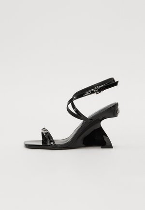 Schwarze Lackleder-Wedge-Sandale mit einem eleganten, offenen Zehendesign, dünnen Knöchelriemen und einem dekorativen Schnallenakzent.