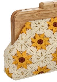 Bolso de mano tejido al crochet con un patrón floral en amarillo y crema, con un cierre de madera y forma estructurada. Textura suave.