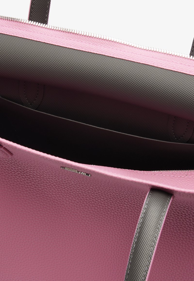Bolso tote de cuero texturizado rosa con una cremallera gris oscuro y un interior a juego. Presenta dos asas y un sutil logotipo de la marca en el costado.