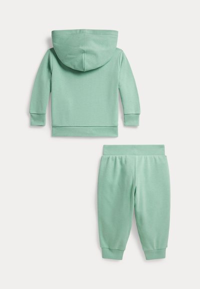 Φούτερ με κουκούλα σε μέγεθος νήπιο, χρώματος μέντας, και αντίστοιχο παντελόνι φόρμας με ελαστική μέση, απλωμένα επίπεδα σε λευκό φόντο.