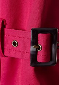 Fuchsia tygbälte med en glänsande svart rektangulär spänne och ett hål med ögla, med kontrasterande sömnadsdetaljer.