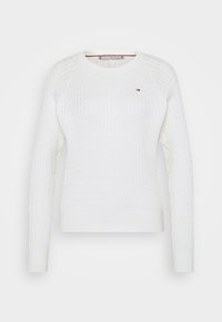 Maglione bianco a maglia con un motivo testurizzato, colletto rotondo e maniche lunghe a raglan. Presenta un piccolo logo sul petto.