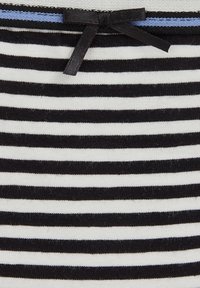 Črnobela črtasta tkanina z gladko teksturo, ki vsebuje majhen črn trak z vozelčkom in vodoravni modri poudarek blizu vrha.