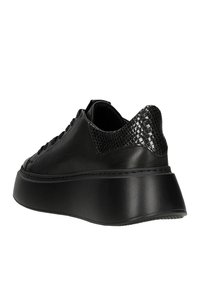 Baskets en simili cuir noir avec un accent en maille noire texturée au talon, semelle plateforme et couture ton sur ton. Surface lisse, design robuste.