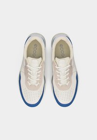 Ζευγάρι λευκά αθλητικά παπούτσια με μπλε λεπτομέρειες, επενδύσεις από μπεζ σουέντ, τρύπες για αερισμό και λευκά κορδόνια, σε θέα από πάνω.