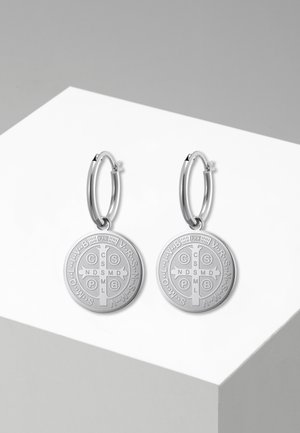Paire de boucles d'oreilles créoles en argent avec médailles rondes de Saint Benoît gravées de symboles religieux et de lettres.