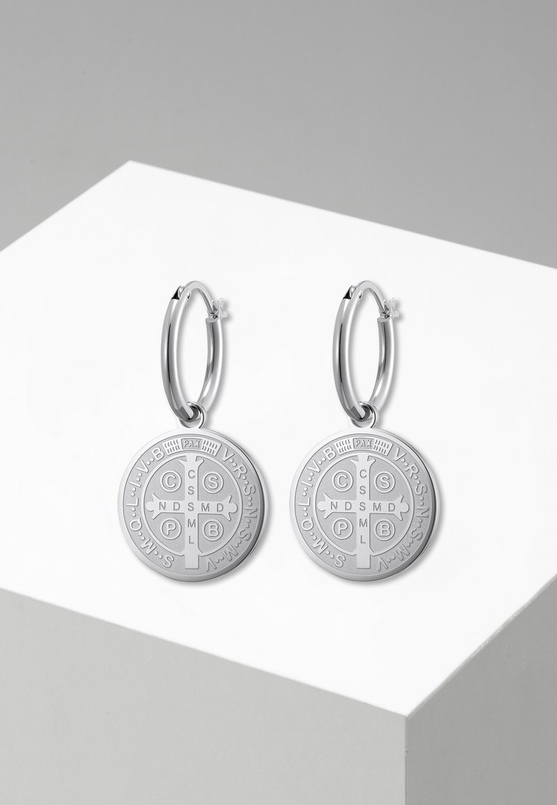Paire de boucles d'oreilles créoles en argent avec médailles rondes de Saint Benoît gravées de symboles religieux et de lettres.
