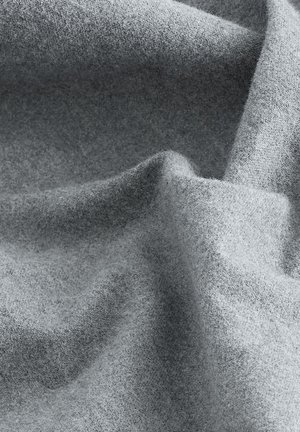 Tessuto in lana grigia drappeggiato, che mostra una texture morbida con fibre sottili e uniformi. La superficie appare leggermente liscia con sfumature sottili.