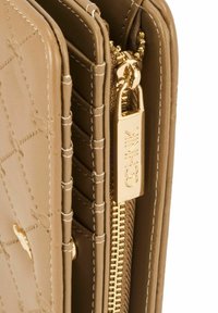 Beżowy portfel z teksturowanej skóry z złotymi akcesoriami, posiadający zamek błyskawiczny oraz wiele kieszeni na karty z przeszyciami.