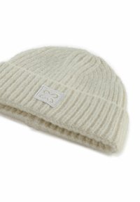 Crème gebreide beanie gemaakt van zachte wol met een ribbelstructuur en een omgeslagen manchet. Beschikt over een klein, geborduurd label aan de zijkant.