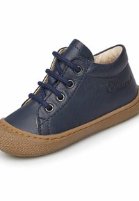 Námořnické kožené vysoké boty s námořnickými tkaničkami, stříbrnými očky a béžovou gumovou podrážkou. Obsahují texturovanou gumovou podrážku a jemný branding.