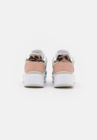 Sko med hvid sål, beige og ferskenfarvede læderdetaljer, samt en tekstureret dyreprint på hælen, med et mønstret mesh-overdel.