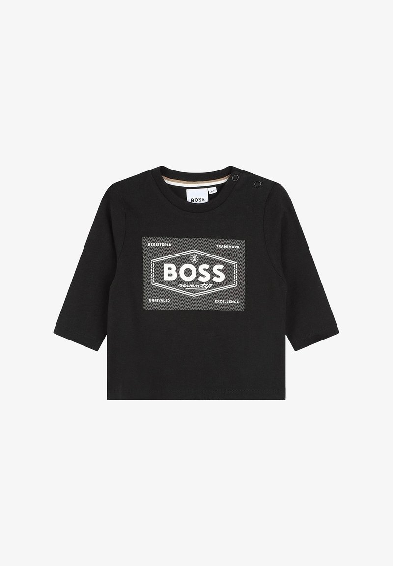Camiseta negra de manga larga hecha de algodón, con un gráfico central en blanco que presenta la palabra "BOSS" y elementos de diseño hexagonales. Detalle de botón a presión en el hombro.